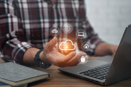 A man  wearing a plaid shirt use Laptop with cloud computing diagram on hand : working at home office technology and network conceptの写真素材