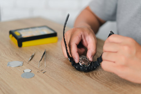 Man hold internal body of the digital watch to check and replace the battery and tools on the tableの写真素材