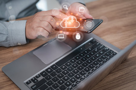 Man uses smartphone and laptop with cloud computing diagram show on hand. payment concept online with the internet and working in officeの写真素材