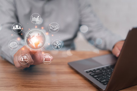 Business work on virtual screen concept: Businessman point Global network connection and use laptops working in an office with blur white wall in backgroundの写真素材