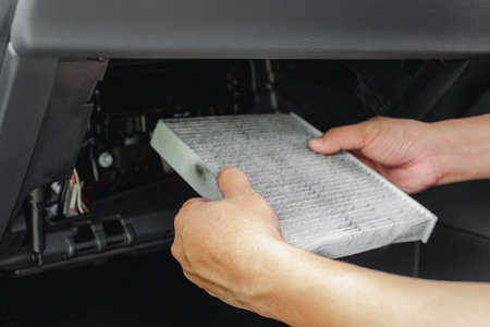 Car service concept hand a man hold old air filter of the car, air conditioning system cleanliness...