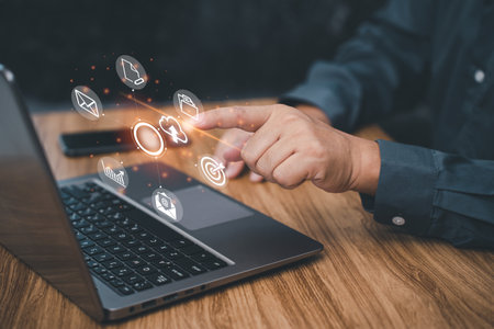 Document management and technology concept, Businessman use a laptop computer with icons on virtual screen working in office and dark cement wall backgroundの写真素材