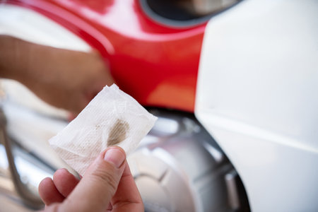 Close up white cloth and engine oil stains a man hold to check the quality of engine oil. to change at the specified distance, basic service conceptの写真素材