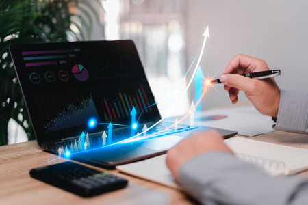 Marketing plan ,analysis graph on virtual screen concept, Businessman use laptops working,point to development graph and growth in financial management Analyzes the profitability of working companiesの写真素材