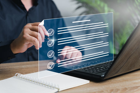 Online Document Management and data checklist,Businessman use a pen marking smart digital checksheet and document management business information to improve work efficiency with laptop on tableの写真素材