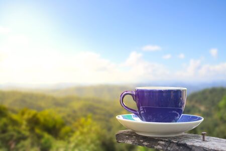 Coffee in a cup on balcony with nature and mountain backgroundの写真素材