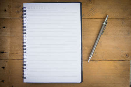 blank notebook and pen on the wooden table for copyspaceの写真素材