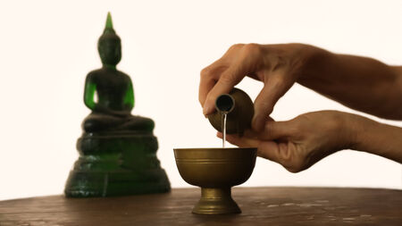 Thai people pour water merit for buddhaの写真素材