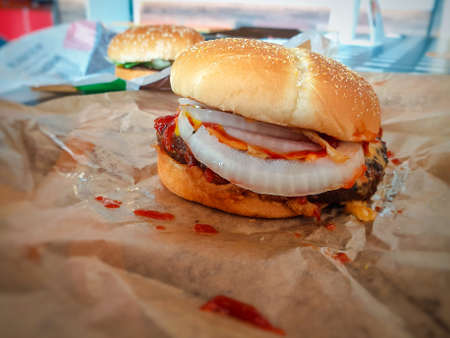 Hamburger is a fast food make from bun, meat, cheese and vegetable  in fastfood restaurant, unhealthy food or fat conceptの写真素材