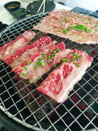 Grilled raw meat beef and pork (barbeque, bbq) a food cooking on wagyu grill in BBQ. yakiniku grill buffet restaurantの写真素材