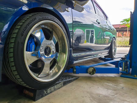 Bangkok, Thailand - August 7, 2021 : Unidentified car mechanic or serviceman disassembly and checking a disc brake and asbestos brake pads for fix and repair problem at car garage or repair shopのeditorial素材