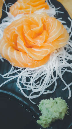 Japanese food delicacy consisting sashimi salmon of very fresh raw salmon fish sliced into thin pieces serving with radish sliced in japan restaurantの写真素材