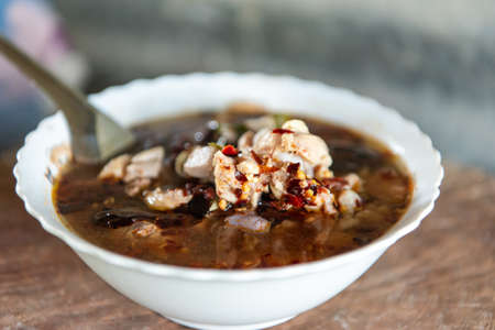 Hot and sour meat soup (Tom Yum) pork or chicken for sale at Thai street food market or restaurant in Thailandの写真素材