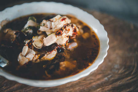 Hot and sour meat soup (Tom Yum) pork or chicken for sale at Thai street food market or restaurant in Thailandの写真素材