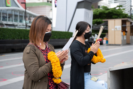 Bangkok, Thailand - October 11, 2021 : Unidentified Thai buddhism people in buddhist pray for benefaction worship by incense and garland to Buddha or spirit-house at shrine or Thai temple (Wat Thai)のeditorial素材