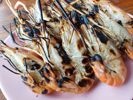 Grilled shrimp (Giant freshwater prawn) grilling with charcoal premium grade display for sale at Thai street food market or restaurant in Bangkok Thailandの写真素材