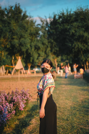 Beautiful asian woman (LGBTQ) natural makeup wear fashion relax clothes posing at nature of flower park or flower garden field lush growing for travel popular landmark in asia outdoor fashion styleの写真素材
