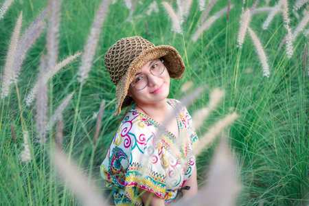 Beautiful asian woman natural makeup wear fashion relax clothes posing at nature of flower park or...