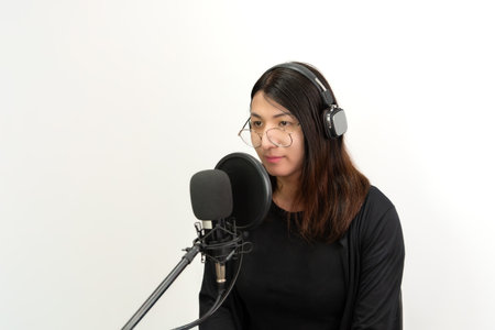 Beautiful asian woman (LGBTQ) is a singer. She enjoying sing a song or karaoke in music studio with microphone condenser and headphones for fun or voice creativeの写真素材