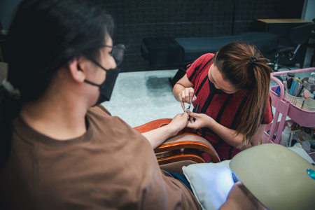 Nail technician do a manicure or pedicure customer nails hand and foot in fashion nail style by gel nails or acrylic at nail salon or beauty salon.の写真素材