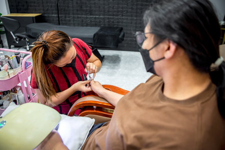 Nail technician do a manicure or pedicure customer nails hand and foot in fashion nail style by gel nails or acrylic at nail salon or beauty salon.の写真素材