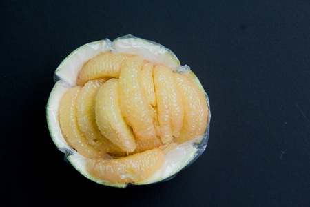 close-up of fresh slice pomelo on black backgroundの写真素材