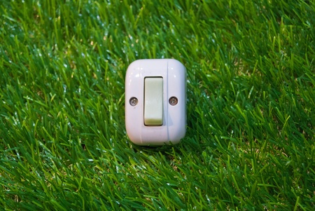 Electrical white rocker light switch on green wallの写真素材