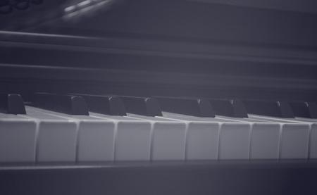 Piano close up at keys in vintage style with light leak effect and vignetteの写真素材
