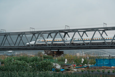 SHIZUOKA, JAPAN - APRIL 6, 2023: Tokaido Shinkansen crossing Fuji View Shinkansen rail bridge in the eveningのeditorial素材