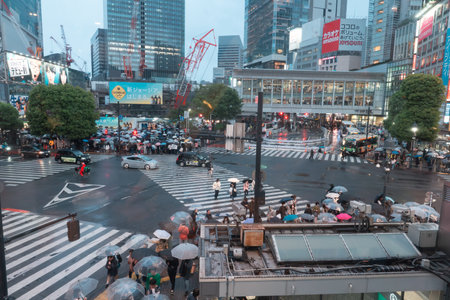 TOKYO, JAPAN - APRIL 8, 2023: View of Shibuya Crossing, one of the busiest crosswalks in the world in a raining dayのeditorial素材