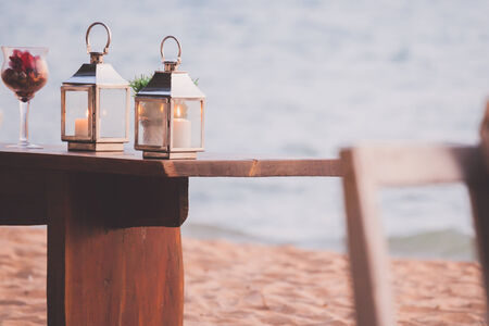 Candle light on the wooden table at the beachの写真素材