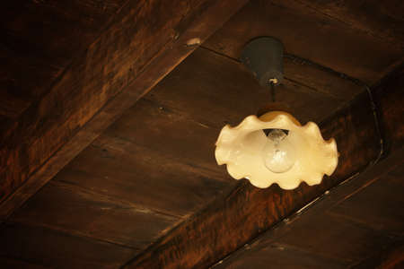 Antique Metal Light Hanging From Old Wooden Barn Ceilingの写真素材