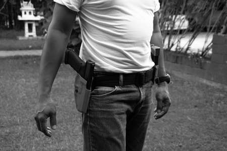 Black and white man and gun ready for shooting training to shooting practice at targets paper.