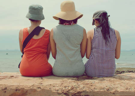 Three Women sit back at side seaの写真素材