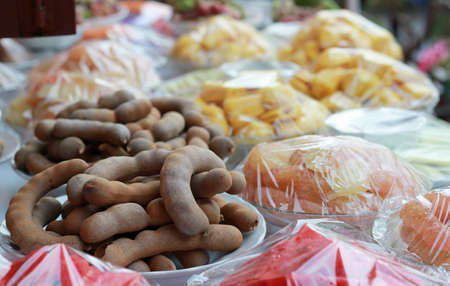 Pile of tammarine on dish with variety fruitsの写真素材