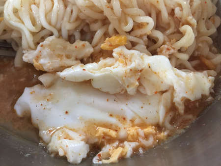 Noodles with egg and garlic in a stainless steel bowl.の写真素材
