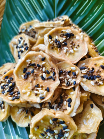 A minimalist composition of round banana sticky bites topped with mixed sesame seeds.の写真素材