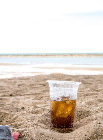 Hot summer glass plastic sparkling water in sandの写真素材
