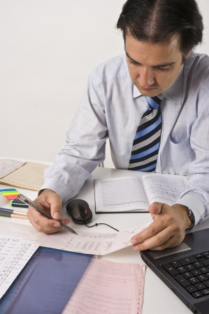 Young man working on table with computer, documents, x-ray pictures, clinical diagrams, prescriptions  Professional clinical research monitor at working place の写真素材