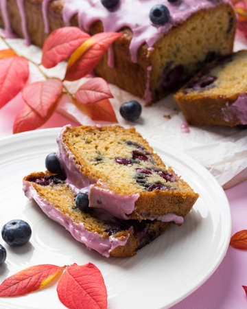 Homemade blueberry cake with pink frosting decorated with berries. Autumn treat for tea time, on...
