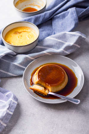 Custard Creme Caramel Flan dessert oven cooked. Homemade milk and egg dessert with caramelized sugar sauce on stone gray backgroundの写真素材