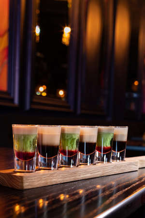 Variety of coffee and mint alcohol cocktail shots in a row at the bar