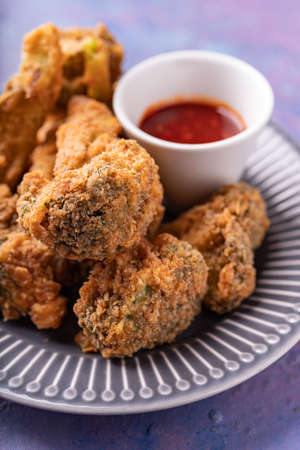 Asian fusion vegan meat-free meal of battered fried broccoli with sweet hot sauceの写真素材