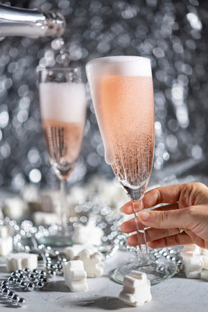 A couple celebrating with sparkling rose wine on grey ornamental backgroundの写真素材