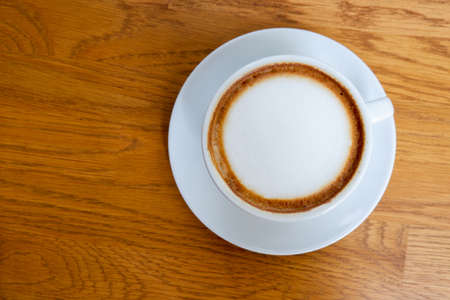 top view coffee in white ceramic cup on wooden floor background, nature wall background, food, drink, copy spaceの写真素材