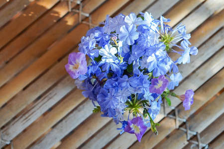 top view violet and blue flowers in glass vase on bamboo  table, blur nature background, nature, decor, object, copy spaceの写真素材