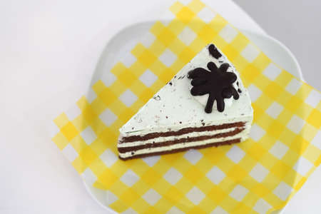 closeup chocolate peppermint cake, placed on a yellow and white plastic plate on a white ceramic plate, white backgroundの写真素材