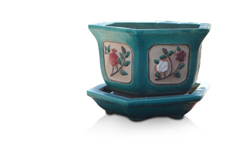 green and cream ceramic pot on green ceramic saucer on white background, object, decor, pottery, ancient, copy spaceの写真素材