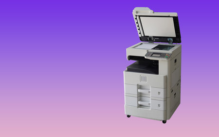 white paper in open black and white digital photocopier and printer on gradient purple and pink...