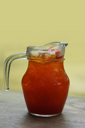 side view lemon tea in a glass jug placed on a wooden floor, wall yellow background, fruit, drink, health, copy spaceの写真素材